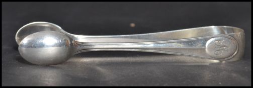 A pair of early 20th century silver hallmarked sugar tongs in the thread pattern having engraved