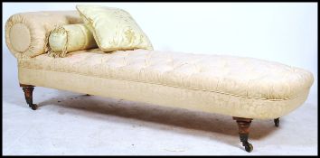 A Victorian mahogany chaise longue being raised on turned legs with castors having overstuffed