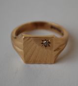 A hallmarked 9ct gold signet ring with sunburst face having a star set diamond. Hallmarked