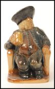 A Royal Doulton Lambeth Armchair Toby- Simeon, cocked hat and feet on plinth 15cm in height.