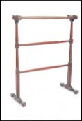 A Victorian 19th century mahogany towel rail stand being raised with turned and spiral fluted