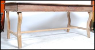 A large 20th century Hardwood refectory dining table in the French style. Raised on shaped legs with