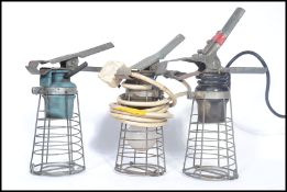 A group of three vintage 20th century retro industrial steel wire caged work lights, each with