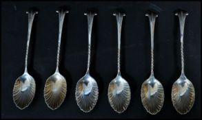 A set of six silver hallmarked shell tea spoons. The bowls in the form of shells with twist stems
