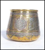 A 19th century Middle Eastern Islamic brass prayer bowl overlaid with silver and copper having