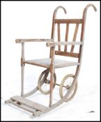 A 19th century Victorian oak invalid chair having wire wheels with shaped supports and handles.