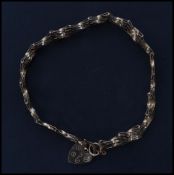 A 9ct gold bracelet chain having a heart padlock clasp. Unmarked but tests as 9ct gold. Weighs 4