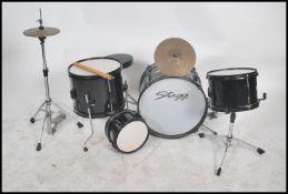 A child's 20th century full drum kit by Stagg to include everything from snare drum to cymbal,