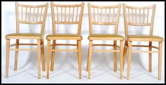 A set of four 1960's beach wood utility gallery rail back dining chairs having tanned leather drop