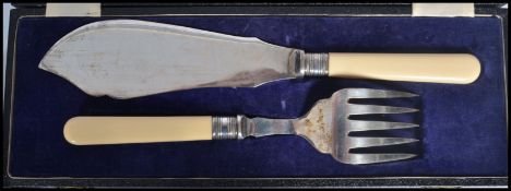 A vintage 20th century Edwardian cased two piece fish serving utensils with ivorine handles and