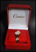 A boxed 20th century Cartier 18ct gold wrist watch set to a stainless steel bracelet. The circular
