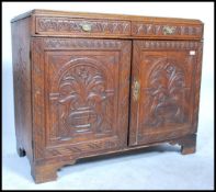 A 19th century country oak cupboard two full length doors swag drop brass handles raised on