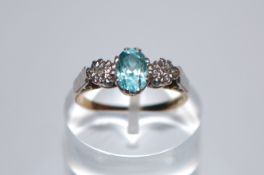 A hallmarked 18ct gold ring set with a central oval cut blue stone flanked by two illusion set