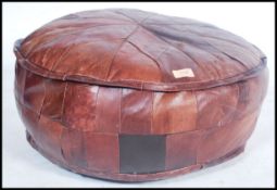 A vintage mid century leather footstool pouffe of barrel form with patchwork leather upholstery, all