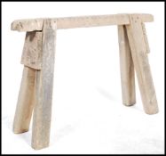 A vintage rustic wooden saw horse / saddle horse having angled legs.