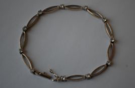 A 9ct white gold bracelet set having oval links with white stone spacers having a clip clasp. Marked