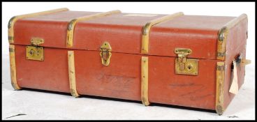 A vintage mid century wooden bound steamer trunk in brown having brass clasps to front.