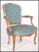 A 20th century French fauteuil armchair made from carved walnut and upholstered in a green fabric