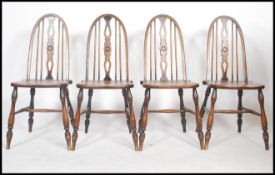 A set of four 19th century elm hoop back dining chairs raised on turned legs with H stretchers.