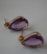 A pair of 9ct gold and amethyst earrings having large faceted pear cut amethyst stones and post