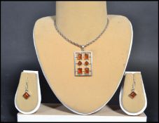 A sterling silver 925 necklace and earring demi-parure set having amber cabochon earrings. The
