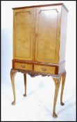 A 20th century walnut drinks / cocktail cabinet in the Queen Anne style, two full length doors