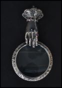 A sterling silver necklace magnifying glass pendant in the form of a mirror and hand having inset