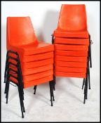 A set of 12 retro 1970's orange plastic and tubular metal stacking chairs. Raised on ebonised