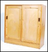 A 20th century industial / utility pine school cupboard / storage unit having two large twin sliding