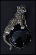 A sterling silver and marcasite brooch in the form of a leopard sat on an onyx moon. Pin to verso