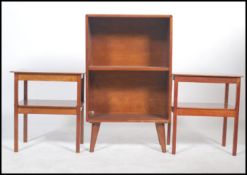 A 1960's retro teak two shelf bookcase raised on tapered angular legs together with a pair of teak