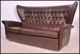 A retro mid 20th century batwing 3 seat sofa settee. In the manner of G-Plan being raised on castors