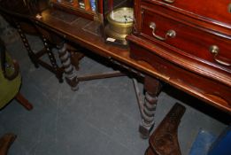 A 1930's oak barley twist draw leaf dining table being raised on barley twist legs with pad feet