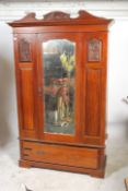 An Edwardian mahogany Art Nouveau wardrobe having a plinth drawer base with shaped legs having