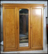 A 19th century Victorian ash / oak triple wardrobe linen press compactum. Raised on a plinth base