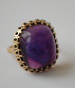 A 1950's hallmarked 9ct gold and amethyst ring set with a large amethyst cabochon in a stylised
