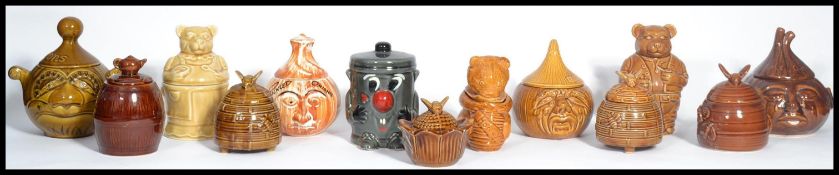 A group of ceramic vintage 20th century retro honey pots in the form of bee hives with bee finials ,