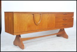 A good 1970's teak wood inverted  sideboard of Danish influence raised on tapering legs with a
