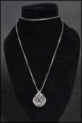 An 18ct white gold and sapphire pendant necklace of art deco form having a central blue sapphire