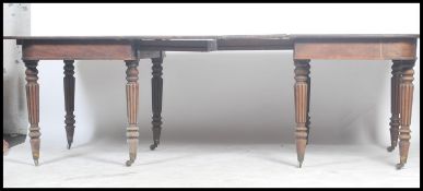 A Georgian 19th century mahogany extending dining table of large form being raised on reeded