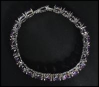 A sterling silver panel bracelet set with amethyst stones having fold over clasp. Weighs 29 grams.