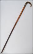 A 19th century Victorian walking stick cane having a tapering wooden shaft with shaped horn