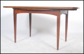 A mid century teak wood Danish inspired dining table raised on tapering supports with extending