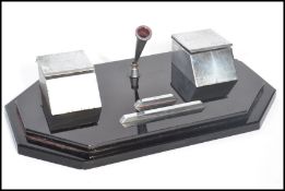 A vintage early 20th century Art Deco twin capstan inkwell desk tidy of black glass construction