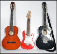 A half sized electric six string Cruiser by Crafton guitar with a red body together with two six