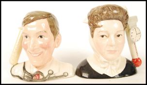 A Royal Doulton pair of Small Character Jugs from The Carry On films; Kenneth Williams D7173 and