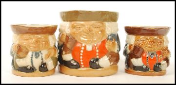 A group of three Doulton Lambeth seated Toby Jugs having impressed marks to base. 8588 5588 and
