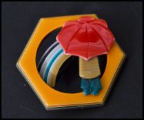 Léa Stein b1936: A vintage 20th century compressed plastic brooch in the form of a rainbow with girl