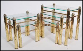 A 20th century brass and glass nest of three occasional tables together with a matching nest of two.