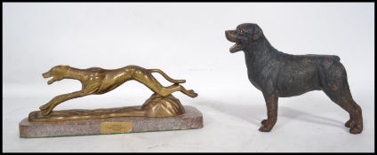 A vintage 20th century painted cast iron figurine of a Rottweiler dog along with a brass figurine of